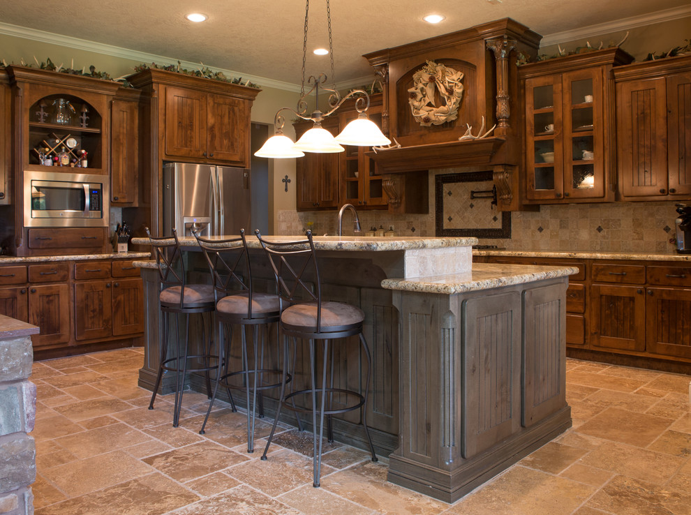 Inspiration for a mid-sized country u-shaped separate kitchen in Austin with shaker cabinets, dark wood cabinets, granite benchtops, beige splashback, stone tile splashback, stainless steel appliances, travertine floors, with island and beige floor.