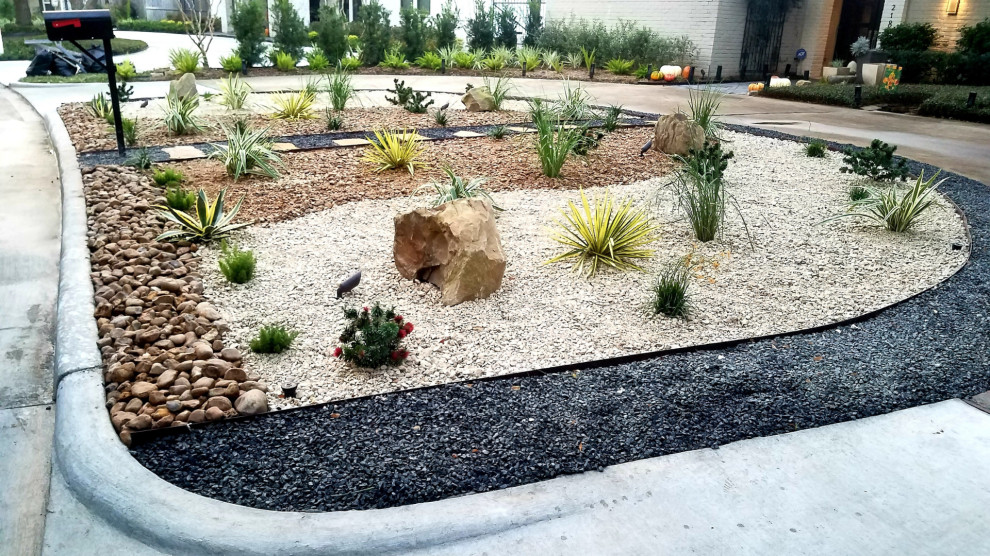 Design ideas for a mid-sized traditional drought-tolerant and full sun front yard river rock flower bed in Other for summer.