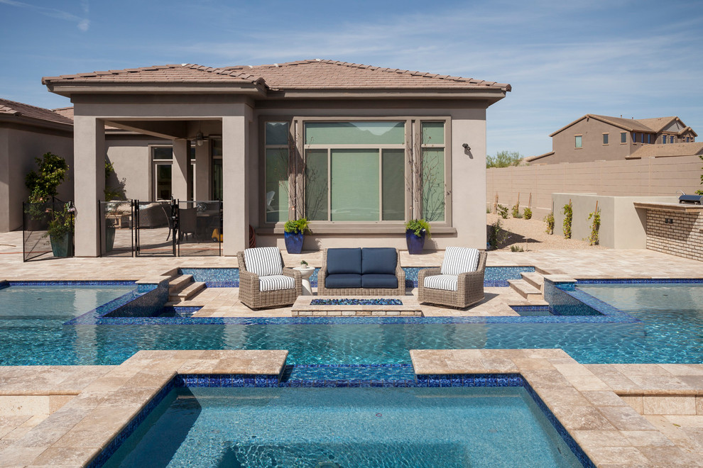 Mid-sized contemporary backyard custom-shaped natural pool in Phoenix with a hot tub and concrete pavers.