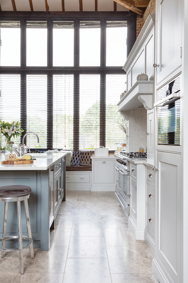 Inspiration for a large contemporary l-shaped open plan kitchen in Essex with a drop-in sink, shaker cabinets, grey cabinets, quartzite benchtops, white splashback, stainless steel appliances, limestone floors, with island, beige floor and white benchtop.