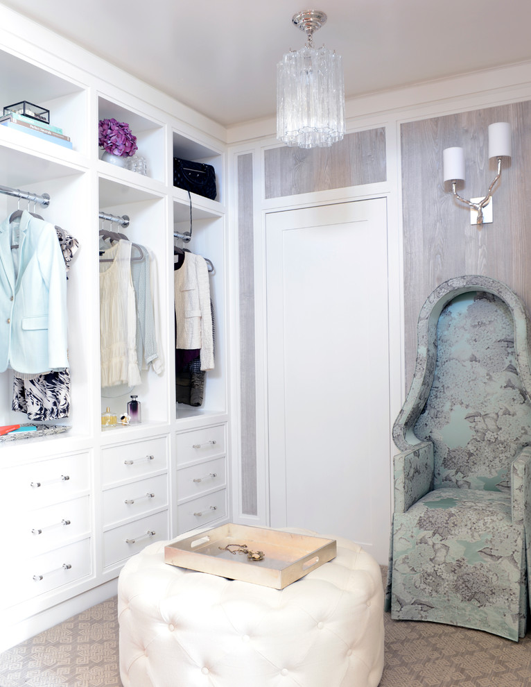 This is an example of a large contemporary women's walk-in wardrobe in New York with shaker cabinets, white cabinets and carpet.