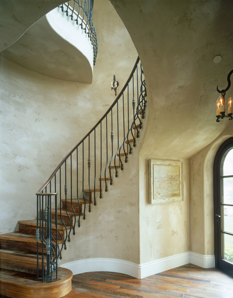 Design ideas for a mediterranean wood curved staircase in San Diego with wood risers.