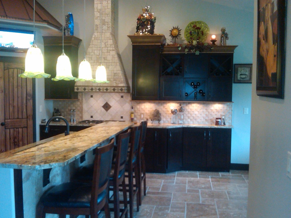 Transitional l-shaped open concept kitchen photo with an undermount sink, shaker cabinets, dark wood cabinets, granite countertops, beige backsplash and stainless steel appliances