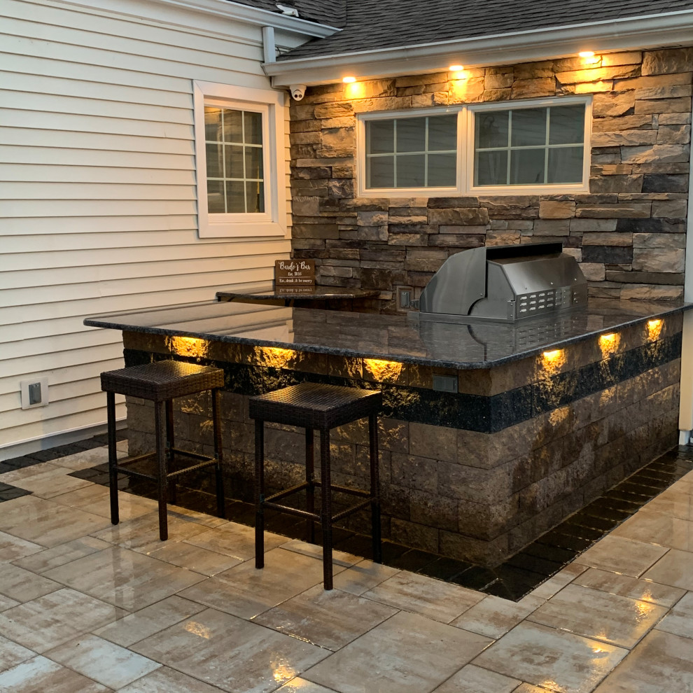 Inspiration for a large contemporary backyard patio in New York with concrete pavers.