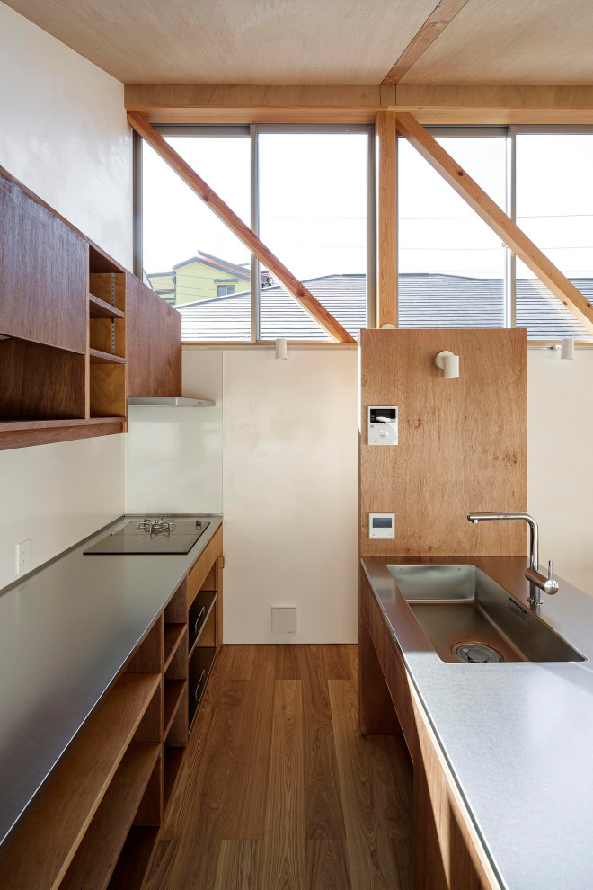 Design ideas for a small modern galley eat-in kitchen in Tokyo Suburbs with an integrated sink, open cabinets, dark wood cabinets, stainless steel benchtops, white splashback, black appliances, plywood floors, with island, beige floor, brown benchtop and wood.