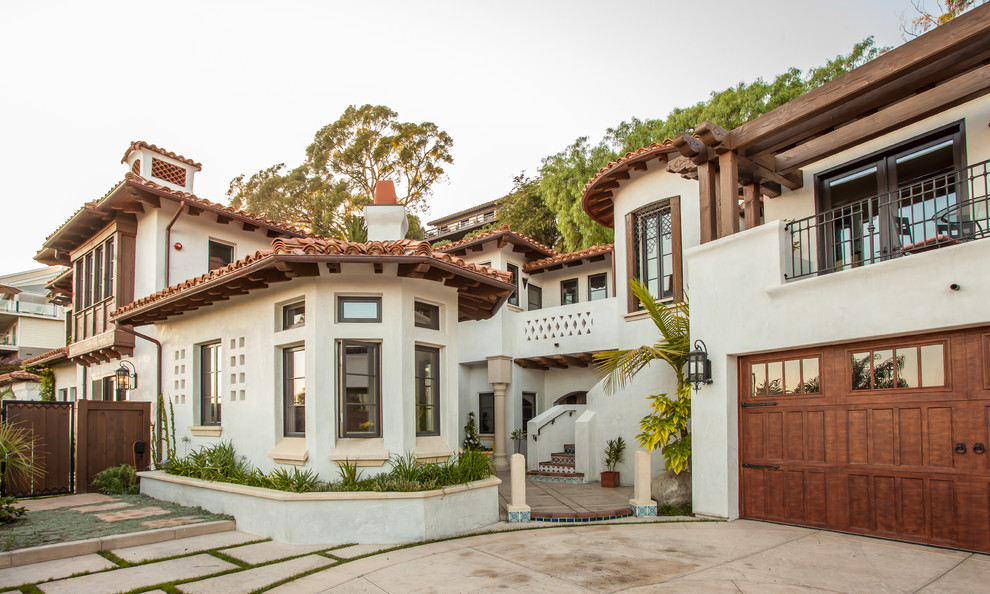 Inspiration for an expansive mediterranean two-storey stucco white house exterior in Santa Barbara with a gable roof and a tile roof.