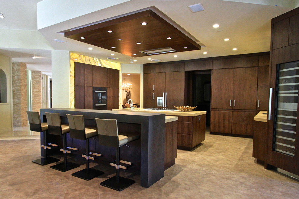 This is an example of a large contemporary l-shaped eat-in kitchen in Orange County with flat-panel cabinets, brown cabinets, quartz benchtops, panelled appliances, porcelain floors, multiple islands, an undermount sink, yellow splashback and glass tile splashback.