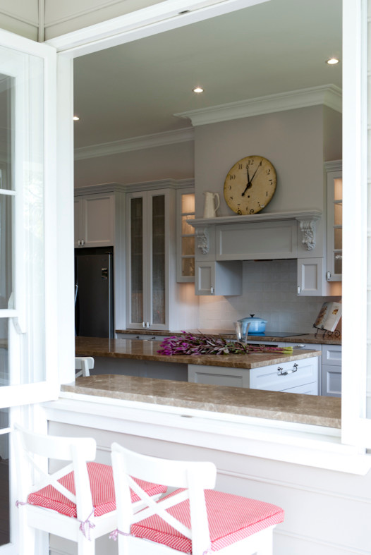 Inspiration for a mid-sized traditional l-shaped eat-in kitchen in Sydney with a drop-in sink, shaker cabinets, yellow cabinets, marble benchtops, white splashback, ceramic splashback, stainless steel appliances, dark hardwood floors and with island.