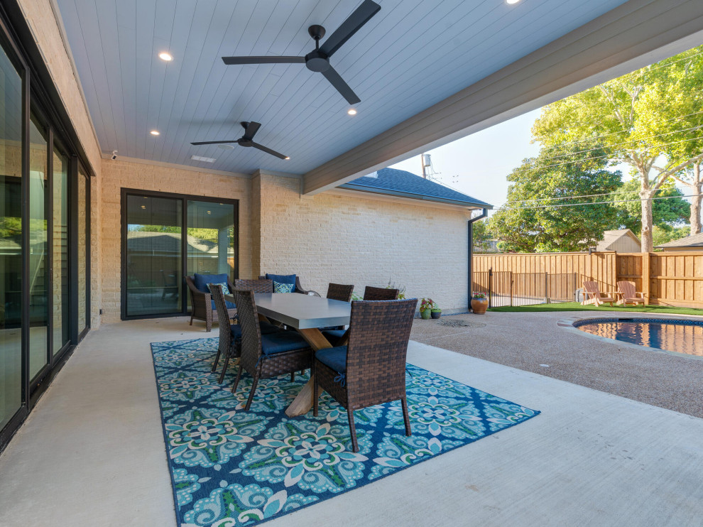 Inspiration for a transitional backyard verandah in Dallas with concrete slab and a roof extension.