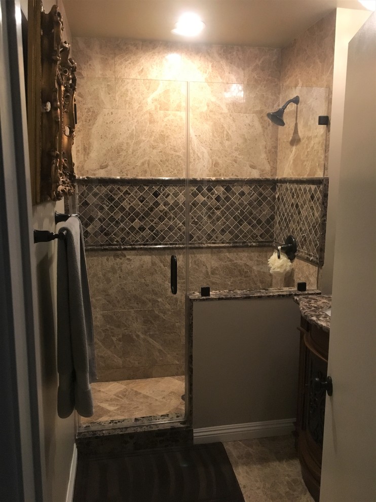 Photo of a small traditional 3/4 bathroom in Los Angeles with raised-panel cabinets, brown cabinets, an alcove shower, a two-piece toilet, brown tile, marble, beige walls, marble floors, an undermount sink, marble benchtops, brown floor and a hinged shower door.