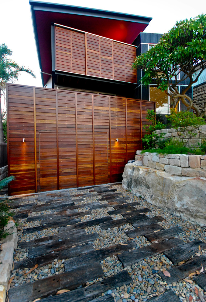 Inspiration for a mid-sized contemporary driveway in Sydney with natural stone pavers.