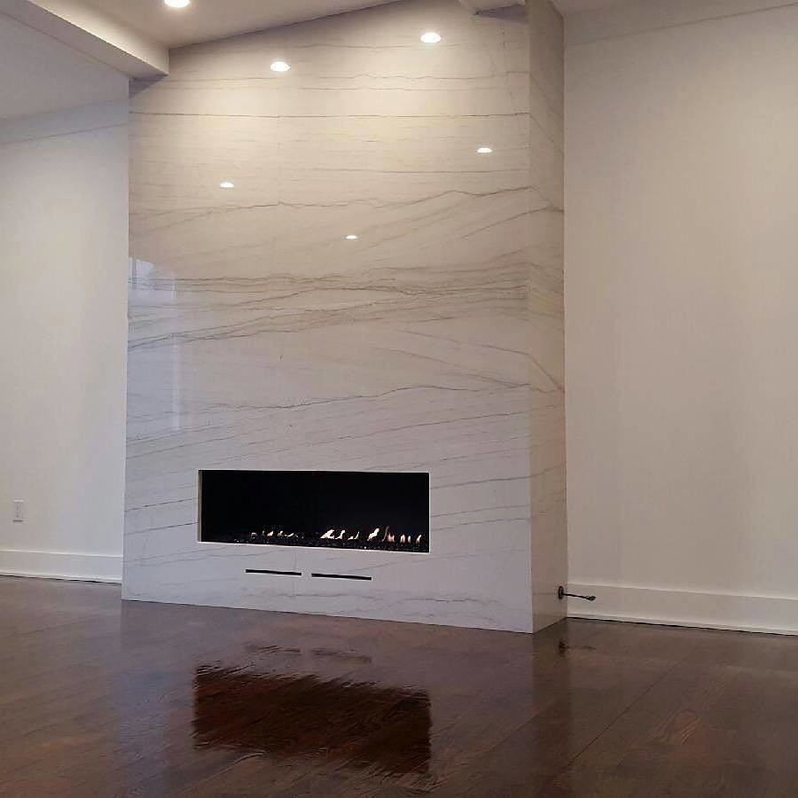 This is an example of a modern living room in New York with a ribbon fireplace and a stone fireplace surround.