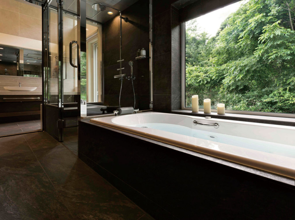 На фото: ванная комната с накладной ванной, черной плиткой, черными стенами, черным полом и многоуровневым потолком с