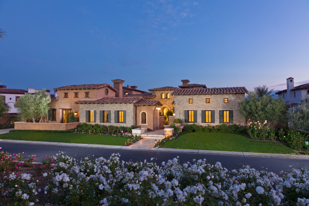 This is an example of a mediterranean two-storey exterior in Orange County with stone veneer.