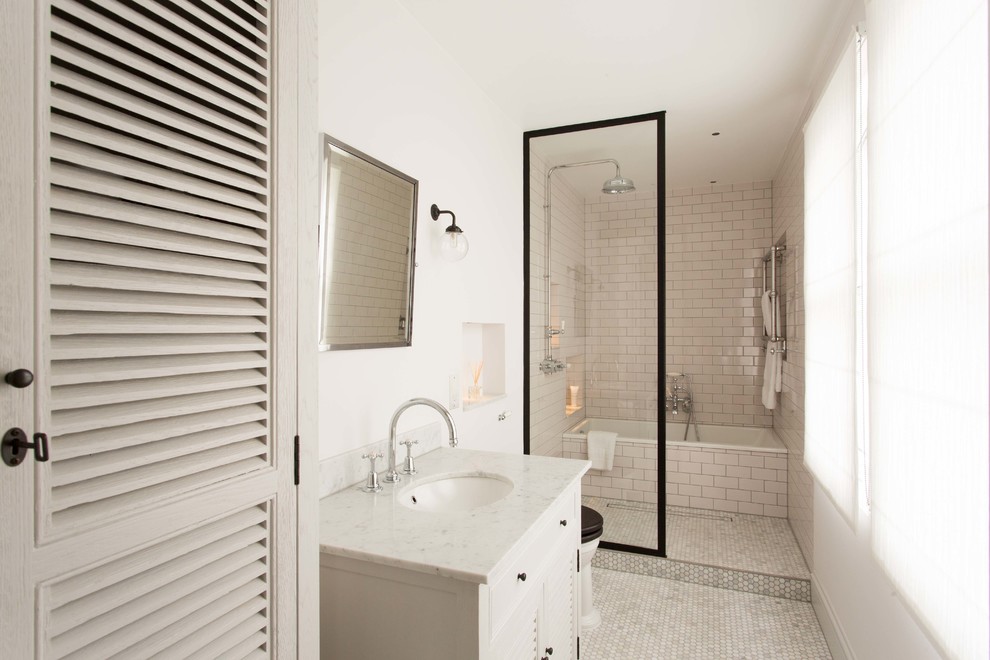 This is an example of a mid-sized contemporary wet room bathroom in London with louvered cabinets, beige cabinets, an alcove tub, beige tile, beige walls and an undermount sink.