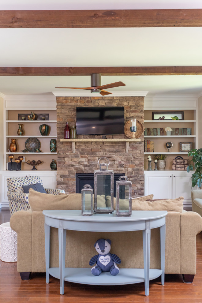 Mid-sized country open concept family room in Raleigh with beige walls, medium hardwood floors, a standard fireplace, a stone fireplace surround, a wall-mounted tv, brown floor, exposed beam and planked wall panelling.