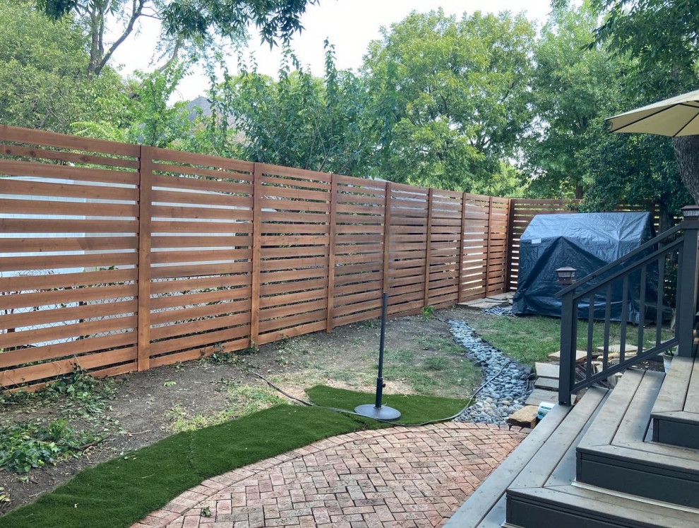 Foto di un giardino country esposto a mezz'ombra di medie dimensioni e dietro casa in estate con pavimentazioni in mattoni e recinzione in legno