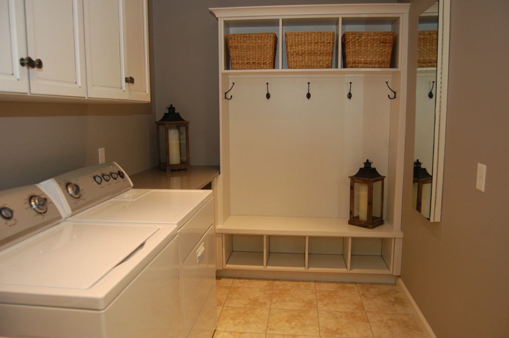 Photo of a small contemporary l-shaped utility room in Philadelphia with shaker cabinets, quartz benchtops, grey walls, vinyl floors, a side-by-side washer and dryer and white cabinets.