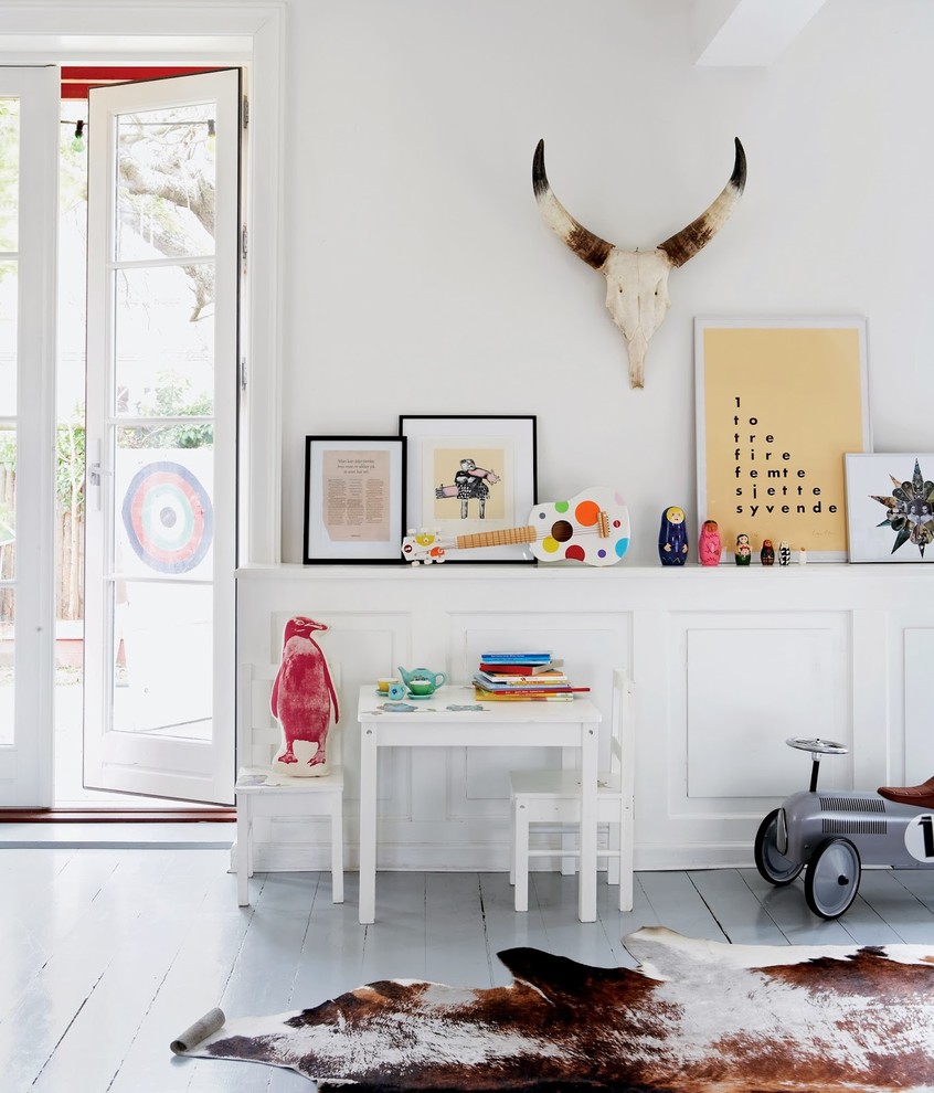Mid-sized scandinavian gender-neutral kids' room in Copenhagen with white walls and painted wood floors.