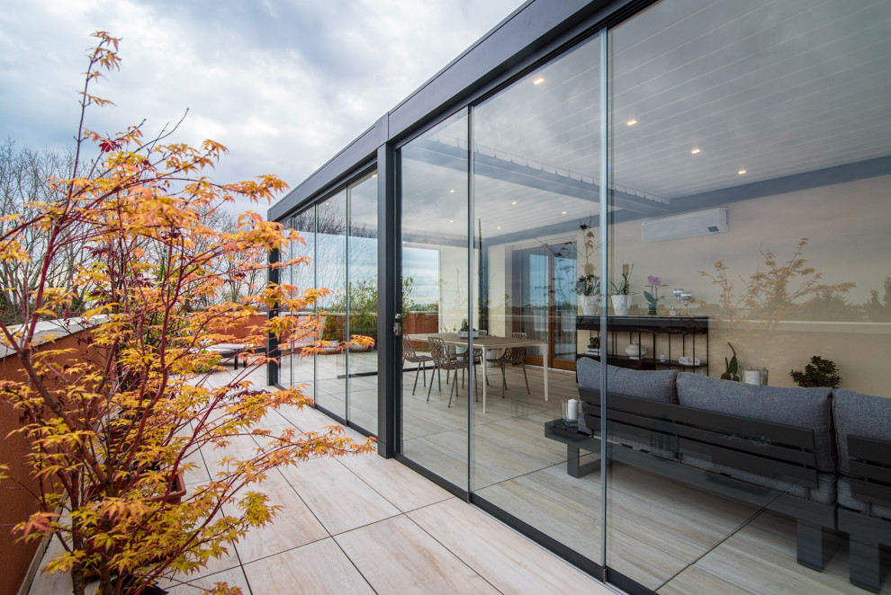 Immagine di una privacy sulla terrazza contemporanea di medie dimensioni, sul tetto e sul tetto con una pergola e parapetto in vetro