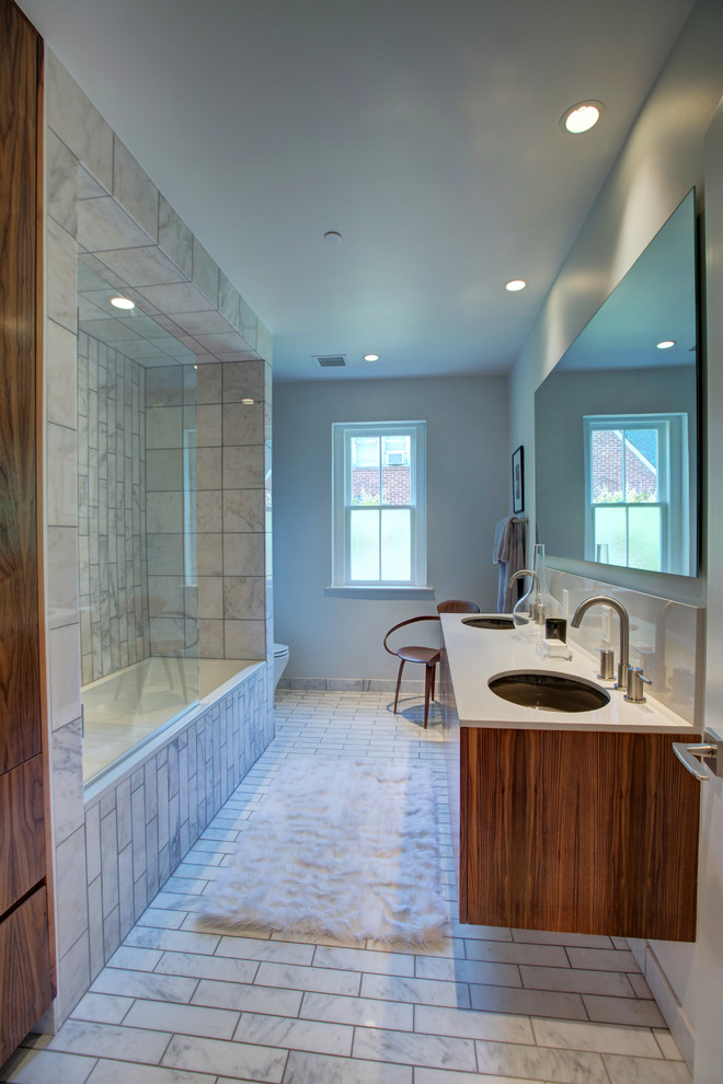 Mid-sized contemporary 3/4 bathroom in Oklahoma City with an undermount sink, flat-panel cabinets, medium wood cabinets, engineered quartz benchtops, a drop-in tub, a wall-mount toilet, white tile, stone tile, white walls, marble floors and a shower/bathtub combo.
