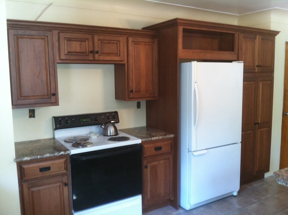 Elegant kitchen photo with beaded inset cabinets, medium tone wood cabinets and white appliances