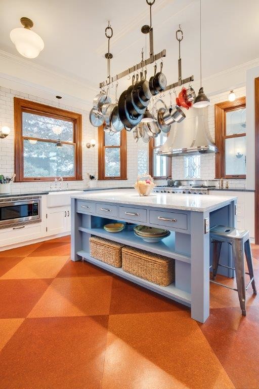 Mid-sized traditional u-shaped eat-in kitchen in Seattle with a farmhouse sink, shaker cabinets, white cabinets, quartz benchtops, white splashback, subway tile splashback, white appliances, cork floors, with island and brown floor.