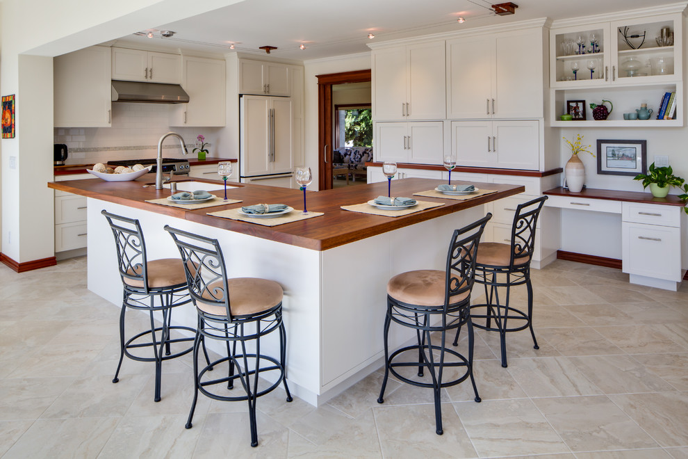Design ideas for a mid-sized contemporary eat-in kitchen in San Diego with an undermount sink, shaker cabinets, white cabinets, wood benchtops, white splashback, subway tile splashback, stainless steel appliances, porcelain floors and with island.
