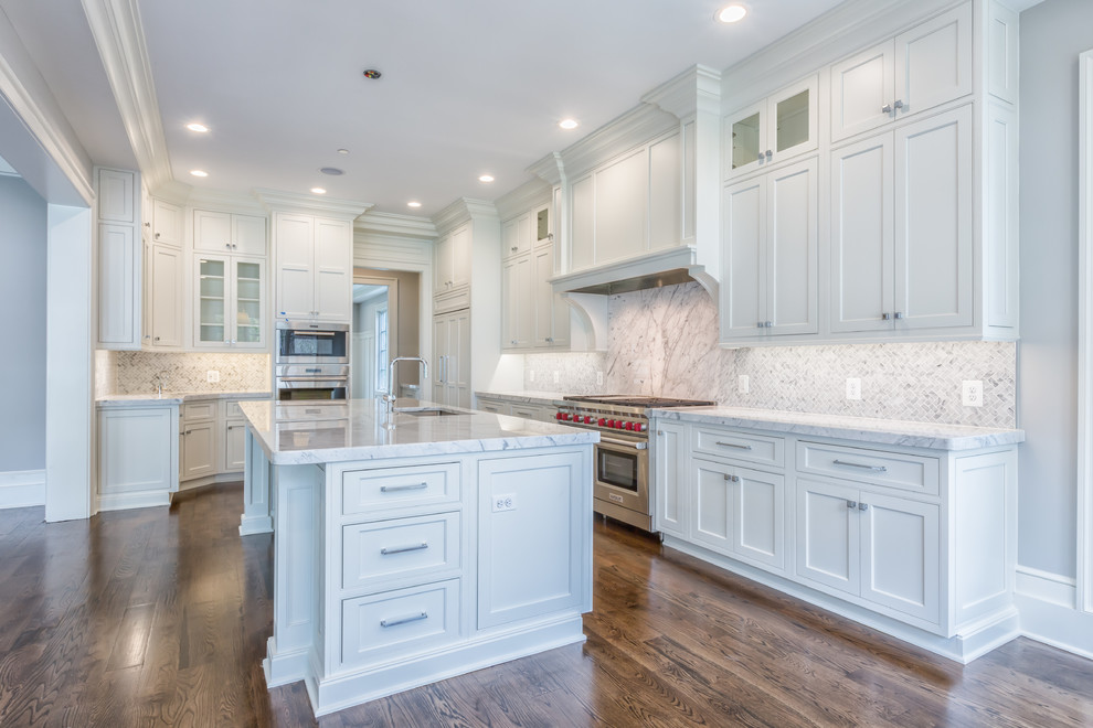 Large transitional u-shaped open plan kitchen in DC Metro with an undermount sink, white cabinets, marble benchtops, multi-coloured splashback, marble splashback, panelled appliances, with island, multi-coloured benchtop, recessed-panel cabinets, dark hardwood floors and brown floor.