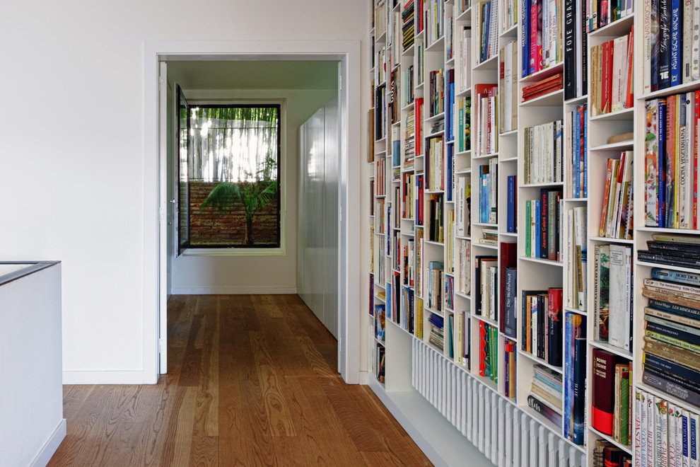 Large eclectic hallway in Barcelona with white walls, medium hardwood floors and brown floor.