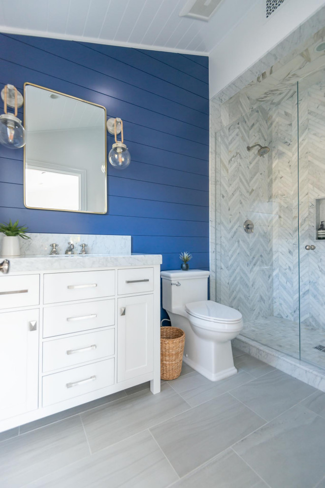 Kleines Maritimes Duschbad mit weißen Schränken, Duschnische, blauer Wandfarbe, Marmor-Waschbecken/Waschtisch, Einzelwaschbecken, Holzdielendecke und Holzdielenwänden in Santa Barbara