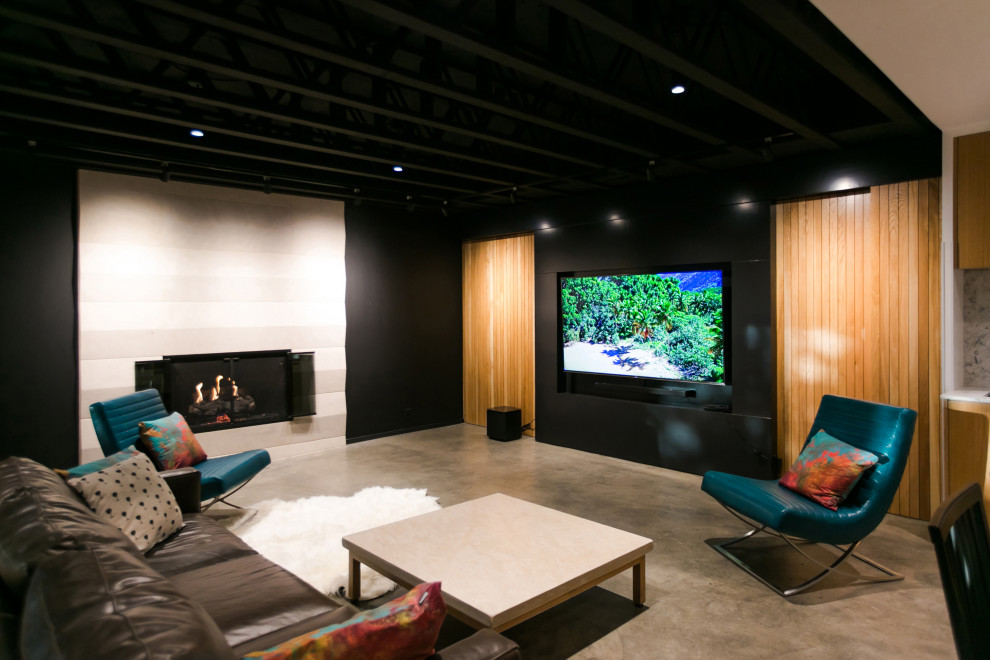 This is an example of a medium sized scandinavian open plan games room in Indianapolis with a home bar, black walls, concrete flooring, a standard fireplace, a stone fireplace surround, a wall mounted tv, grey floors, exposed beams and wood walls.