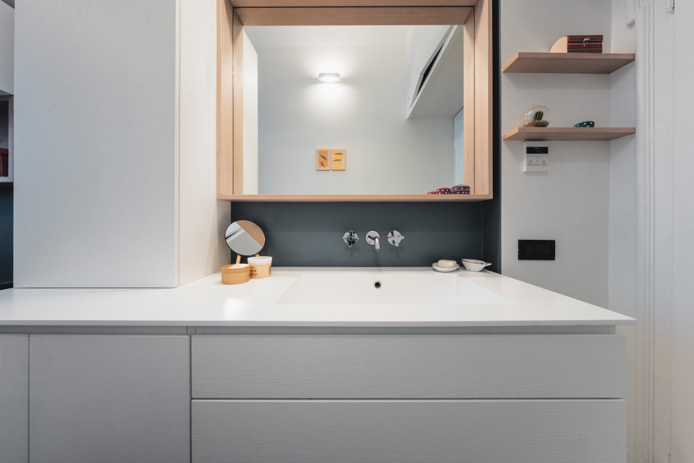Imagen de cuarto de baño largo y estrecho, único y flotante, actual, pequeño, con armarios con paneles lisos, puertas de armario blancas, ducha empotrada, sanitario de dos piezas, baldosas y/o azulejos multicolor, baldosas y/o azulejos de porcelana, paredes multicolor, suelo de baldosas de porcelana, aseo y ducha, lavabo encastrado, encimera de acrílico, suelo turquesa, ducha con puerta corredera y encimeras blancas