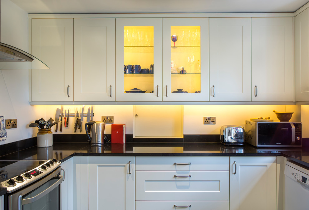 This is an example of a transitional kitchen in Buckinghamshire with shaker cabinets and granite benchtops.