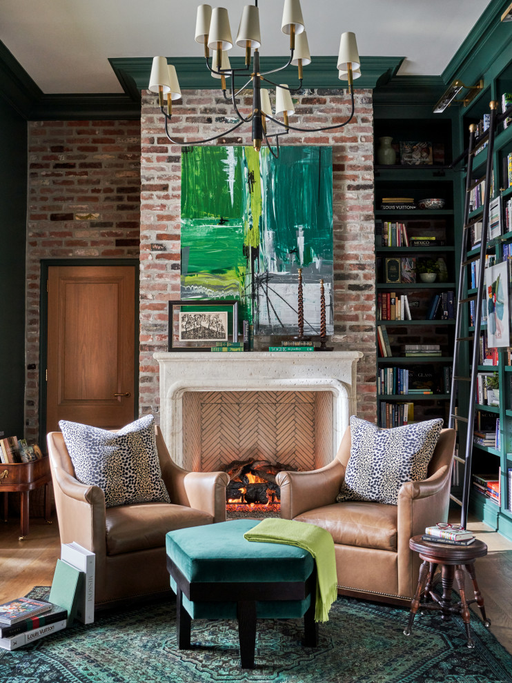 Large transitional home office in Other with a library, green walls, medium hardwood floors, a standard fireplace, a freestanding desk, brown floor and brick walls.