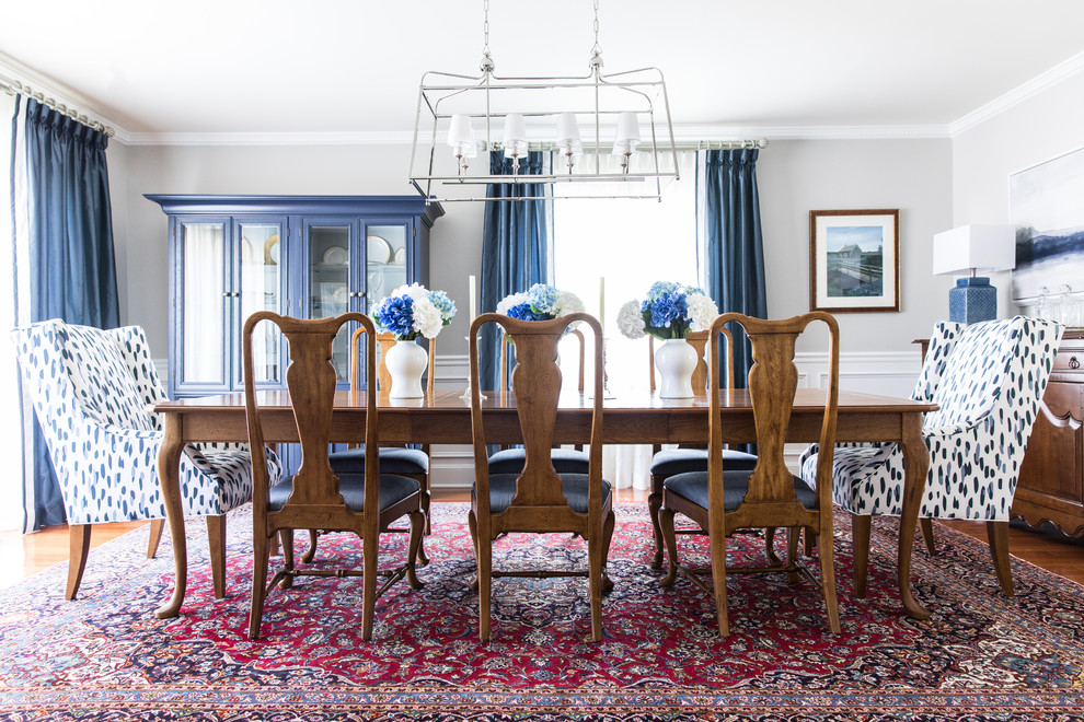 Elegant medium tone wood floor enclosed dining room photo in Charlotte with gray walls