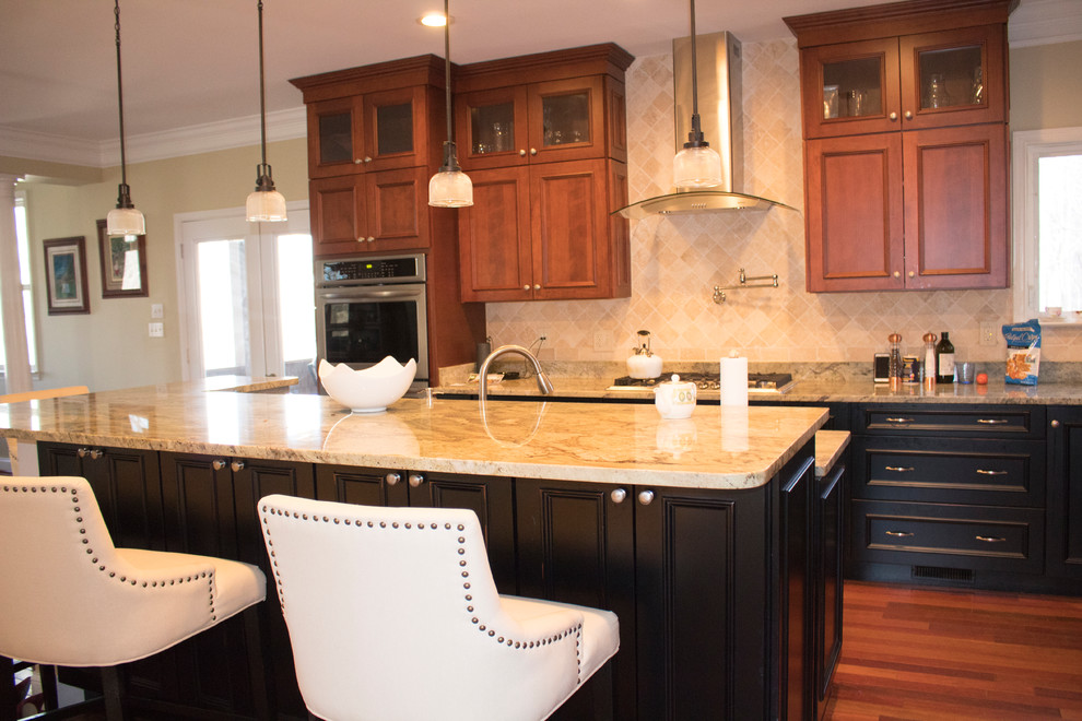 Example of a large transitional l-shaped dark wood floor and brown floor enclosed kitchen design in DC Metro with an island, raised-panel cabinets, dark wood cabinets, a double-bowl sink, granite countertops, beige backsplash, limestone backsplash and stainless steel appliances