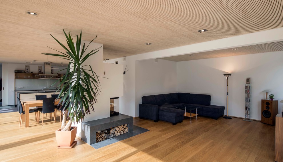 Großes, Repräsentatives, Offenes Modernes Wohnzimmer mit hellem Holzboden, Kaminofen, beigem Boden, verputzter Kaminumrandung und weißer Wandfarbe in München