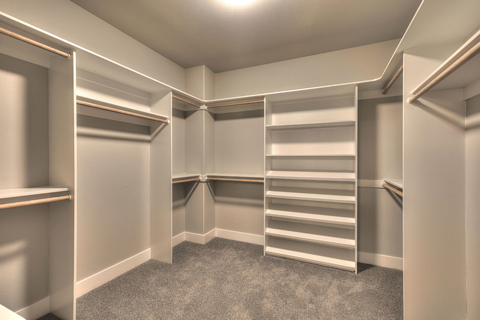 Large transitional gender-neutral dressing room in Portland with open cabinets, white cabinets, carpet and grey floor.