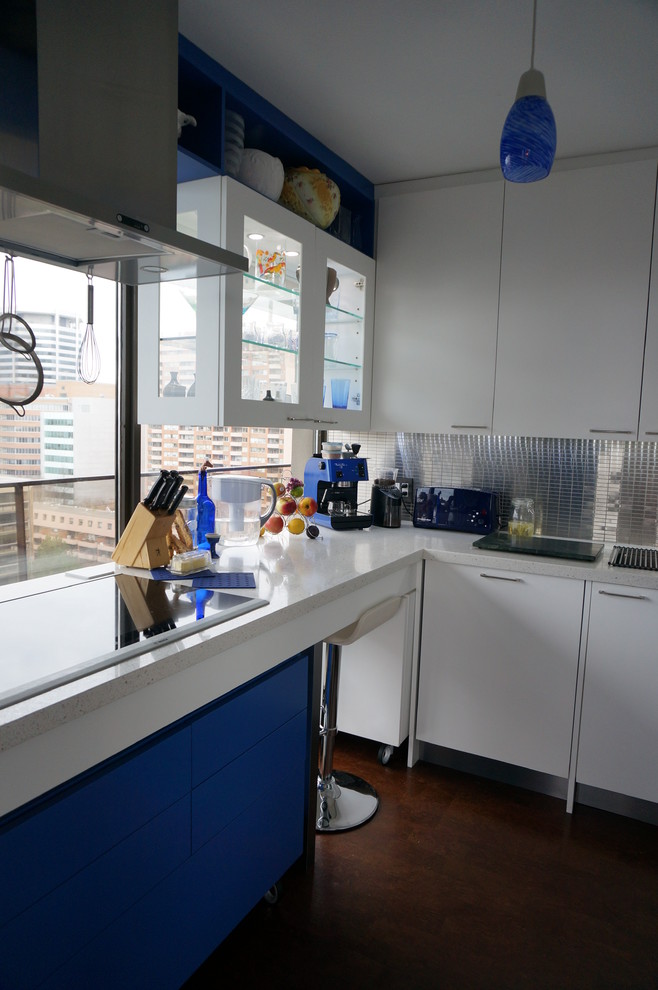 Kitchen - small transitional u-shaped kitchen idea in Toronto with flat-panel cabinets, white cabinets, solid surface countertops, metallic backsplash, metal backsplash and stainless steel appliances