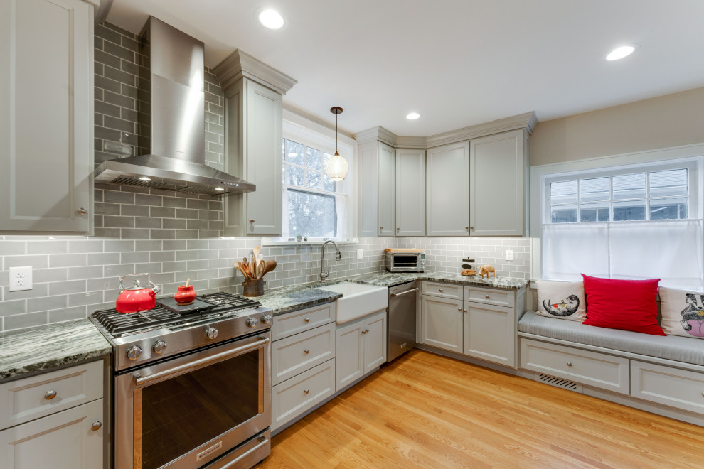 Example of a small classic l-shaped light wood floor and brown floor enclosed kitchen design in Columbus with a farmhouse sink, shaker cabinets, green cabinets, granite countertops, green backsplash, stainless steel appliances, no island and green countertops