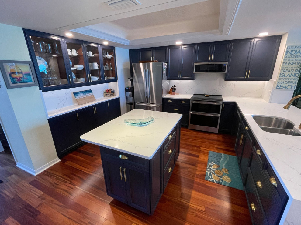 This is an example of a mid-sized modern u-shaped eat-in kitchen in Tampa with blue cabinets, quartz benchtops, engineered quartz splashback and with island.