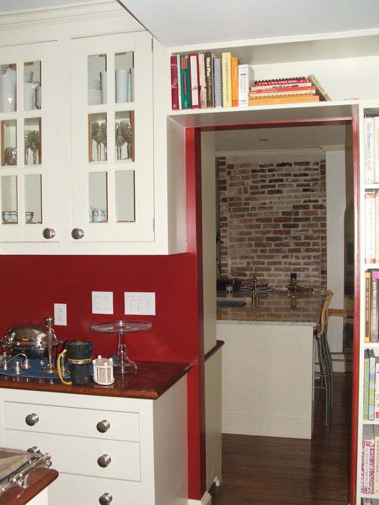 Example of a dark wood floor enclosed kitchen design in Boston with shaker cabinets and white cabinets