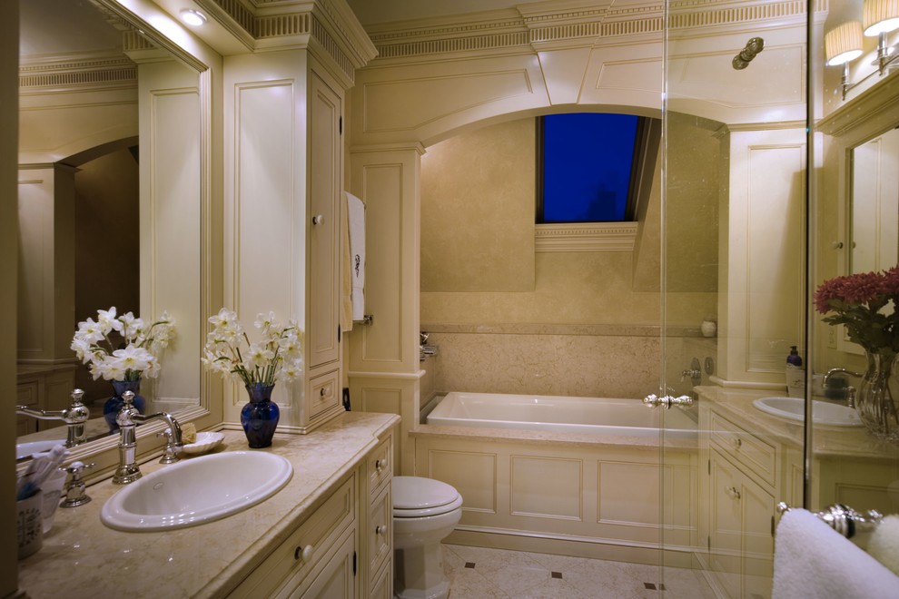 Mid-sized traditional master bathroom in Newark with beaded inset cabinets, beige cabinets, a drop-in tub, a corner shower, an urinal, beige tile, black walls, limestone floors, a drop-in sink, limestone benchtops, beige floor and a hinged shower door.
