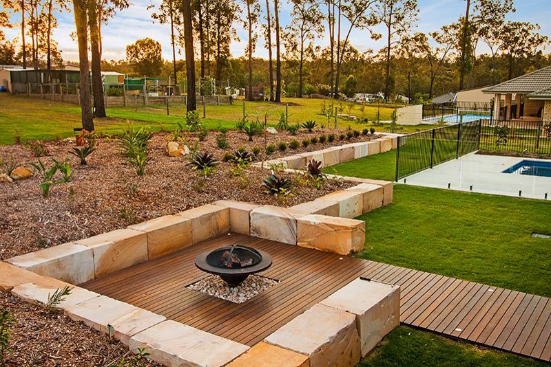 Inspiration for a large contemporary backyard full sun garden for winter in Brisbane with a fire feature and decking.
