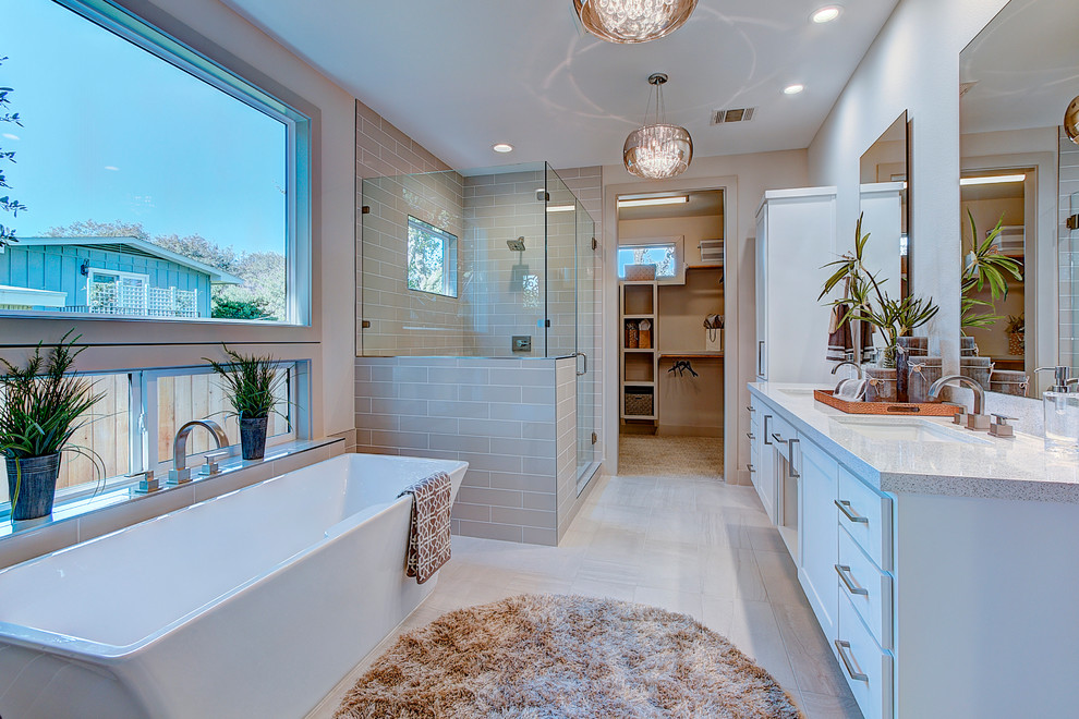 Inspiration for a transitional master bathroom in Austin with shaker cabinets, white cabinets, a freestanding tub, a corner shower, an undermount sink, grey floor, a hinged shower door and grey benchtops.