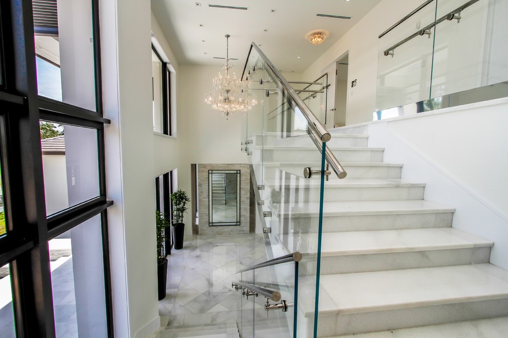 Large modern foyer in Miami with white walls, marble floors, a double front door, a glass front door and white floor.