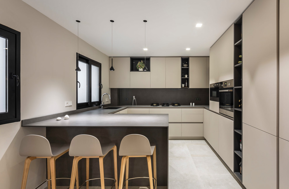 Inspiration for a contemporary kitchen in Valencia with flat-panel cabinets, grey splashback, stainless steel appliances, a peninsula and grey benchtop.