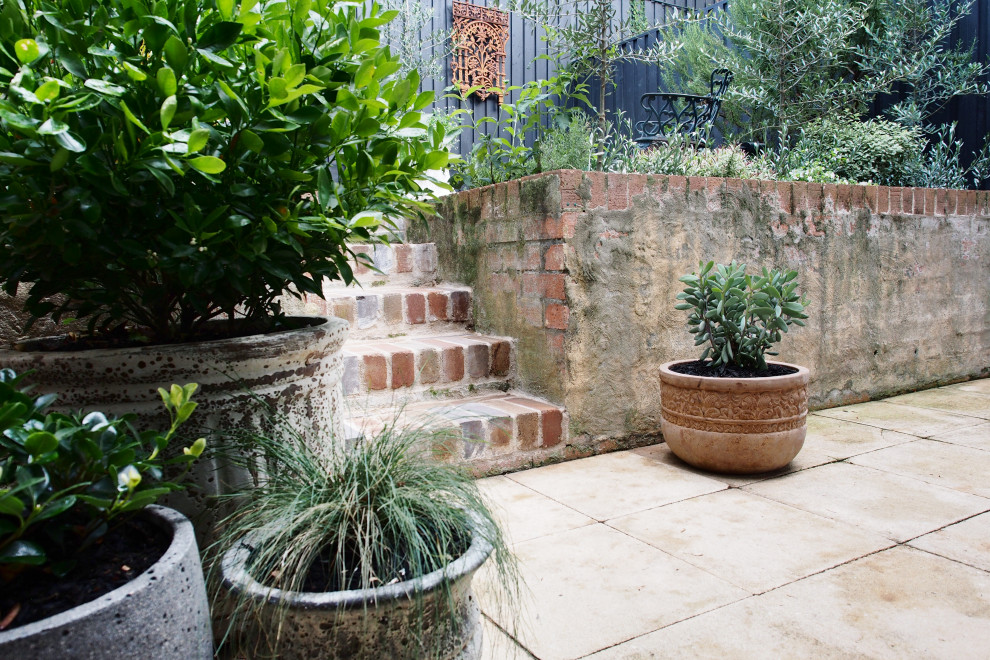 This is an example of a small country courtyard partial sun garden for spring in Sydney with brick pavers.