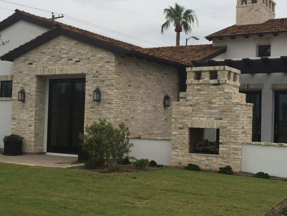 Large two-storey white exterior in Phoenix with stone veneer and a gambrel roof.